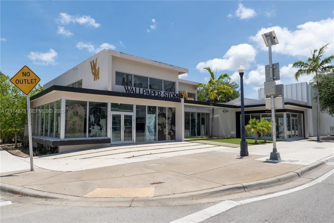 Commercial building exterior featuring floor-to-ceiling storefront glass, flat roof architecture, concrete sidewalk frontage, and multi-level facade design