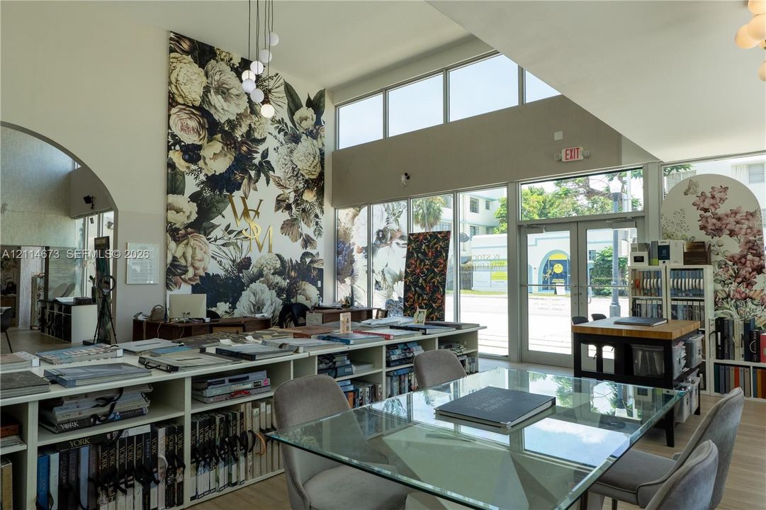 High-ceiling room featuring expansive floor-to-ceiling windows, clerestory windows, built-in floor-to-ceiling shelving, and decorative wall murals