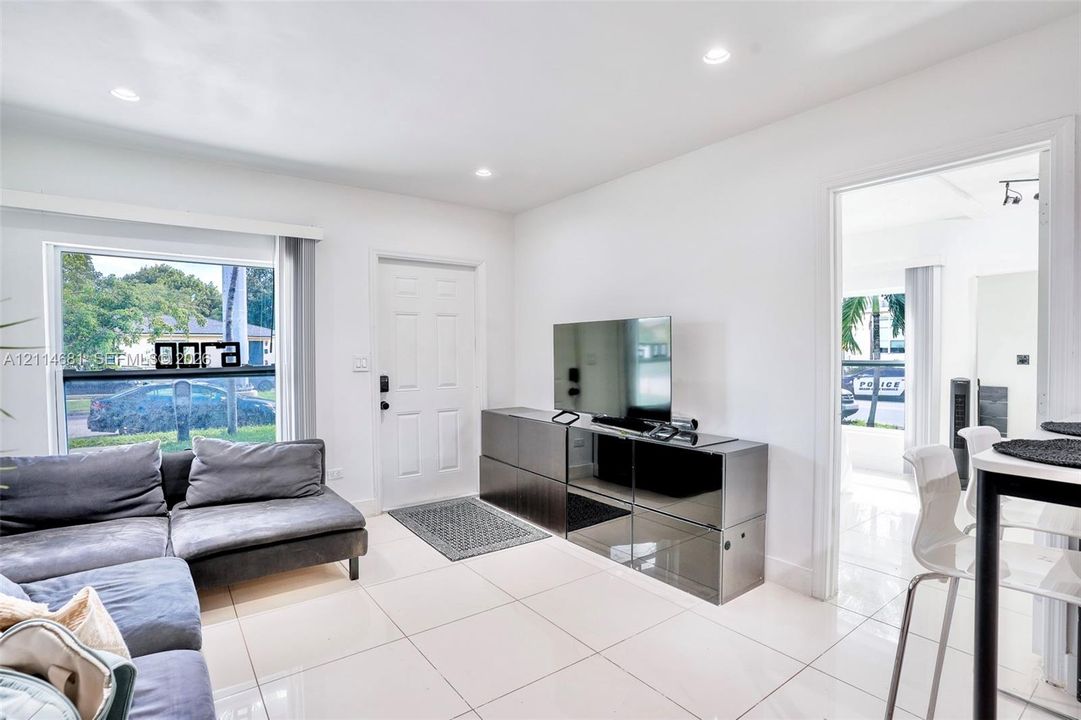 Neutral-toned tile flooring, recessed ceiling lighting, and large window with natural light