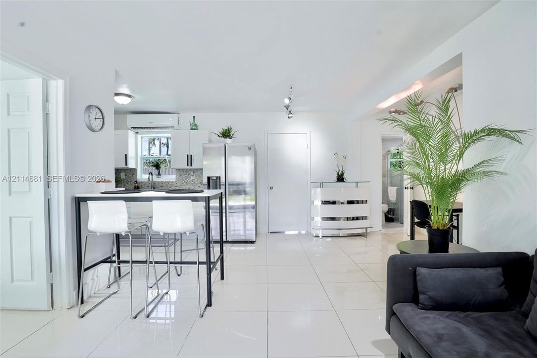 Kitchen featuring white cabinetry, stainless steel side-by-side refrigerator, multi-directional track lighting, and white tile flooring