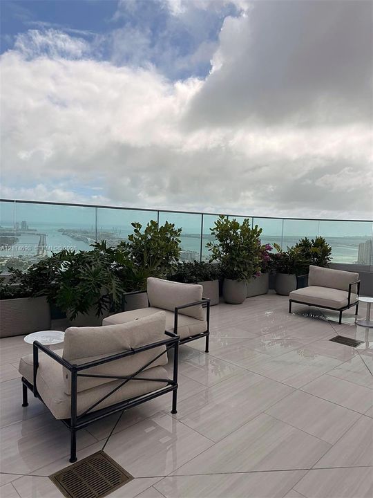 Expansive terrace featuring large-format tile flooring and a seamless glass railing