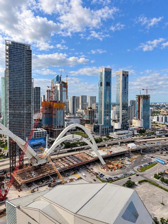 Elevated perspective of the metropolitan skyline featuring high-rise towers, multi-lane infrastructure, and expansive urban scenery