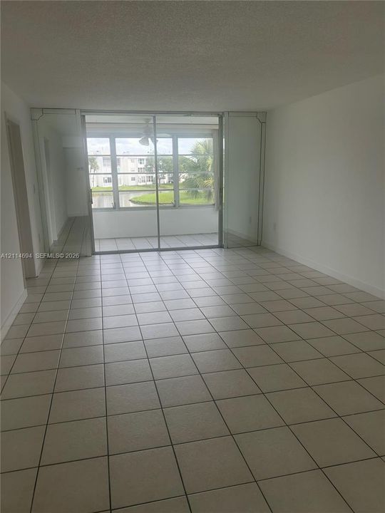 Ceramic tile flooring, mirrored wall accents, and sliding glass doors with exterior access to an enclosed balcony