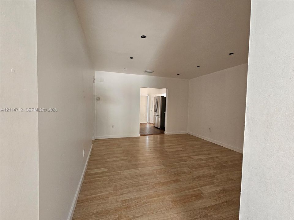 Neutral-toned interior space featuring light wood-finish flooring and recessed ceiling lighting