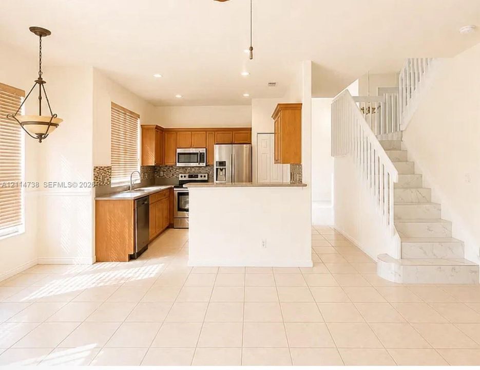 Kitchen featuring wood cabinetry, stainless steel appliances, and tile backsplash