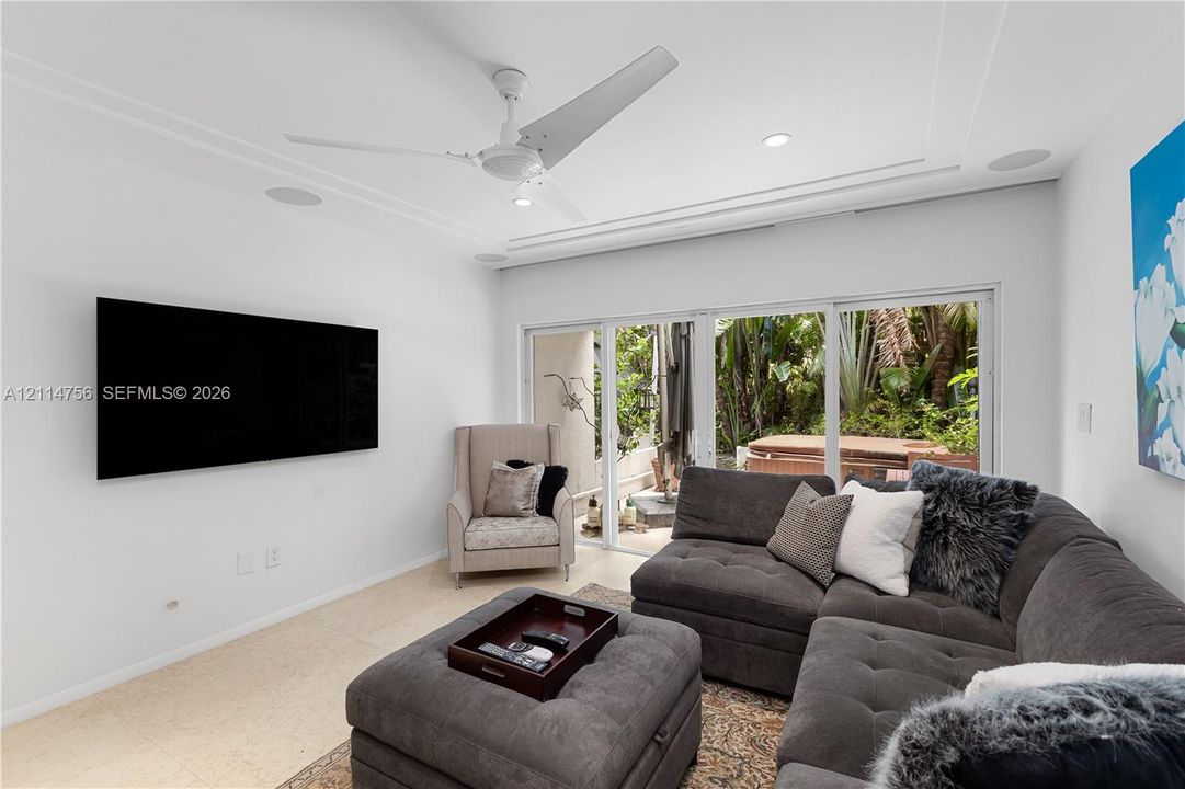 Living area featuring recessed lighting, a modern ceiling fan, stone flooring, and expansive sliding glass doors