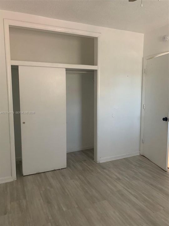 Wood-finish flooring, sliding closet door with overhead storage compartment, and solid-core interior doors