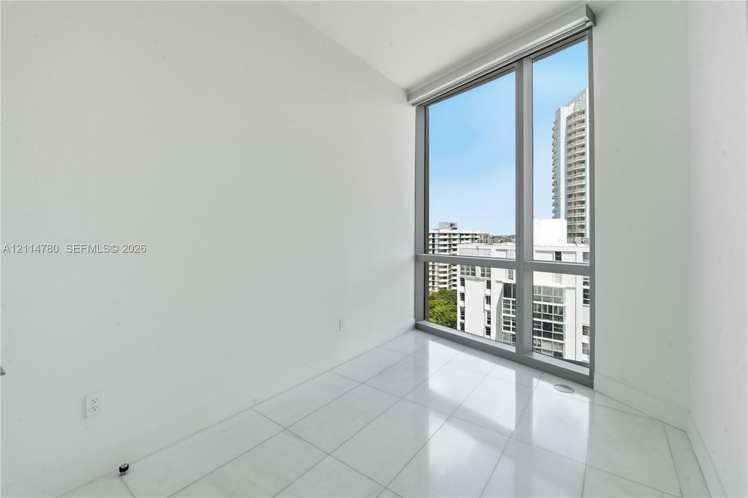 Floor-to-ceiling windows featuring metallic frames, neutral wall finishes, and polished tile flooring