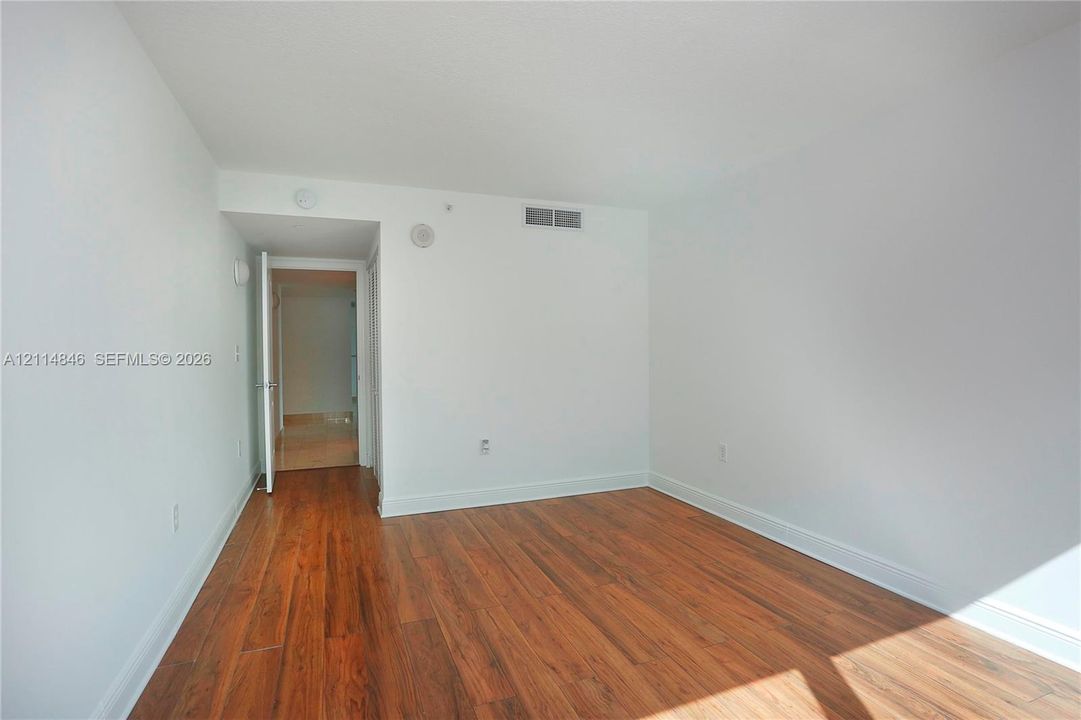 Interior space featuring neutral wall paint and wood-finish flooring