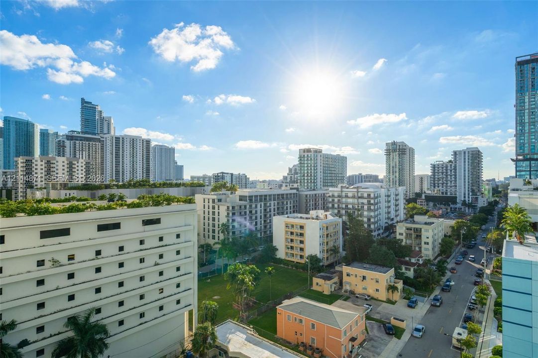 Elevated perspective of the urban landscape featuring high-rise structures, paved thoroughfares, and mature palm trees