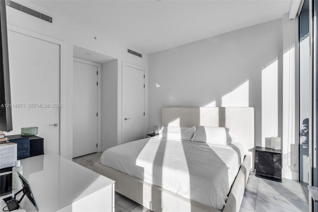 Minimalist room featuring stone-finish flooring, floor-to-ceiling glass wall, and solid-core interior doors