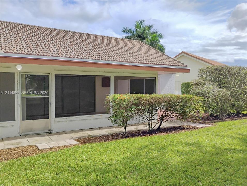 Screened-in lanai featuring a tile patio, concrete block construction, and a concrete tile roof