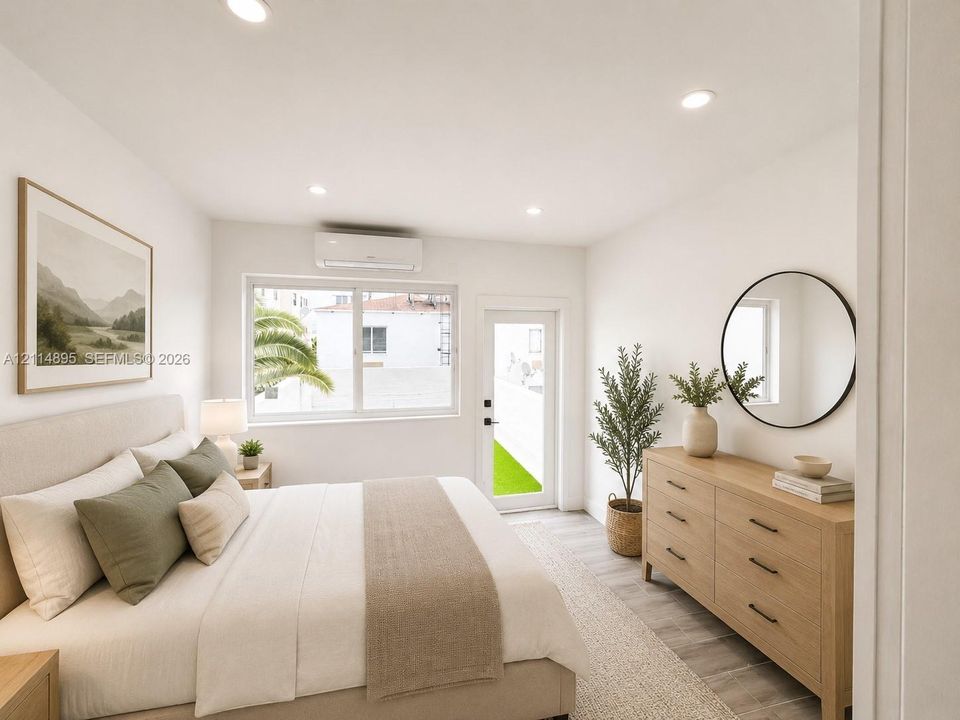 Room featuring recessed lighting, wood-finish flooring, a wall-mounted ductless heating and cooling unit, and a glass-paneled exterior door