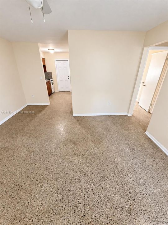 Interior space featuring polished concrete flooring, ceiling-mounted light fixtures, and white paneled doors