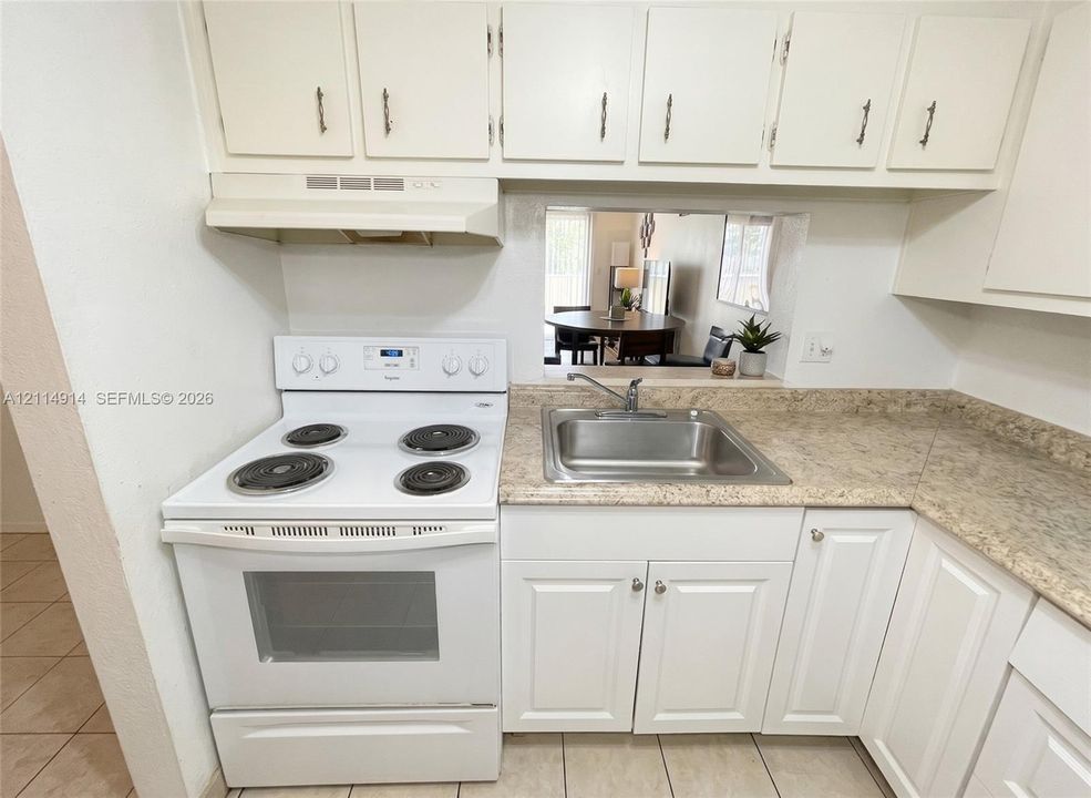 Kitchen featuring white cabinetry, stone-finish countertops, stainless steel sink with a metallic faucet, and a white electric range with overhead ventilation