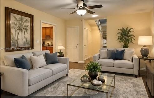 Living space featuring a central ceiling fan with integrated lighting, wood-finish flooring, and paneled interior doors