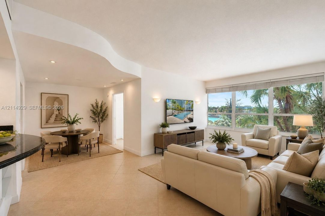 Open-concept interior featuring a curved architectural soffit, large-format tile flooring, recessed lighting, and wall-to-wall windows