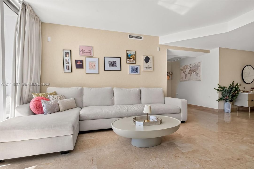 Natural stone flooring throughout, floor-to-ceiling glass paneling, and smooth-finish walls