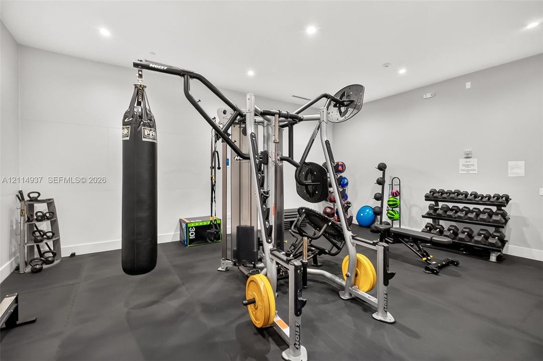 Dedicated exercise space featuring recessed lighting and durable rubber flooring