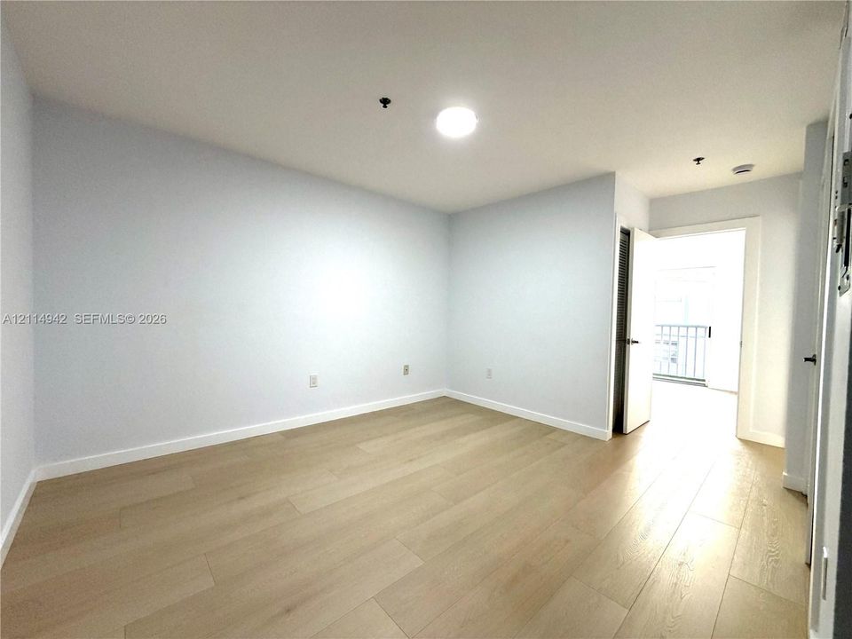 Light-filled room featuring wood-finish flooring, neutral wall paint, and recessed lighting