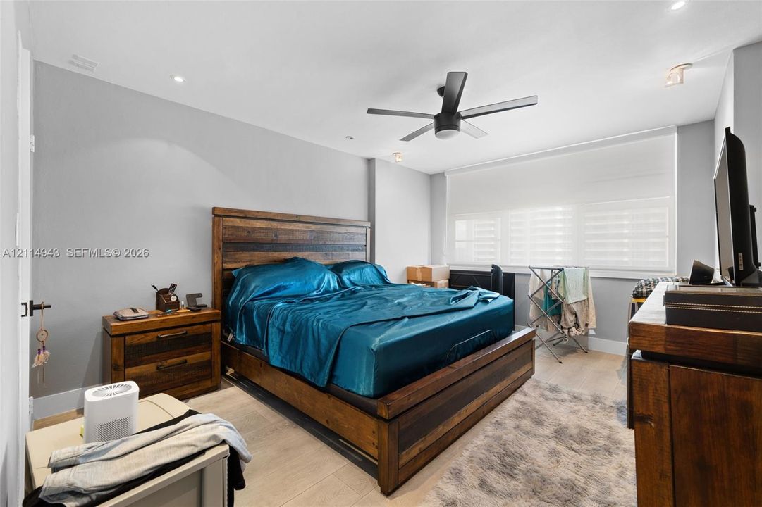 Neutral-toned interior featuring recessed lighting, a multi-blade ceiling fan, light-finish flooring, and white window shades