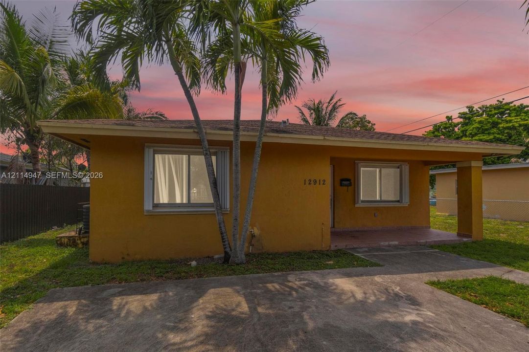 Single-story exterior featuring a covered front porch, concrete driveway, and sliding glass windows