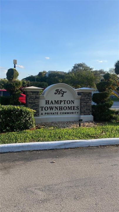 Community entrance signage featuring stone masonry pillars and manicured landscaping