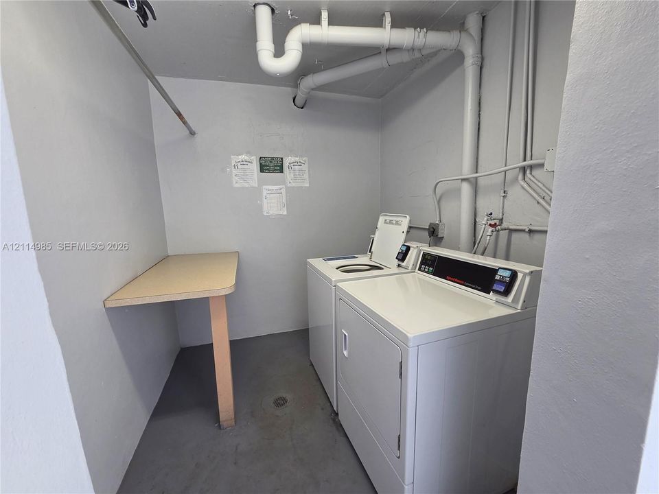 Laundry area featuring a top-load washer, a front-load dryer, and a built-in folding counter