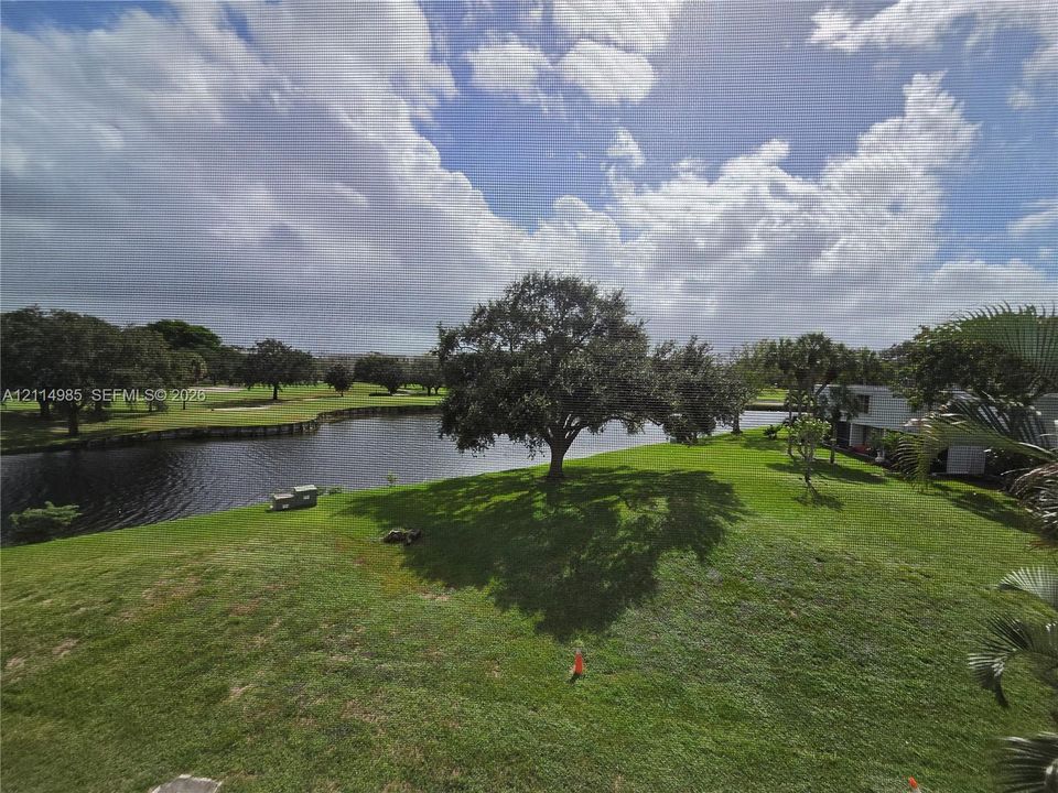 Expansive grounds featuring a water frontage, mature trees, and open green space