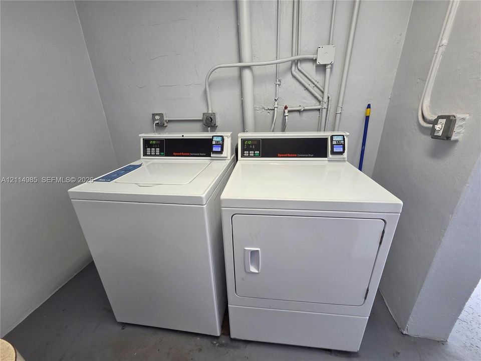 Laundry area featuring top-load washing machine and front-load dryer with white exterior finishes
