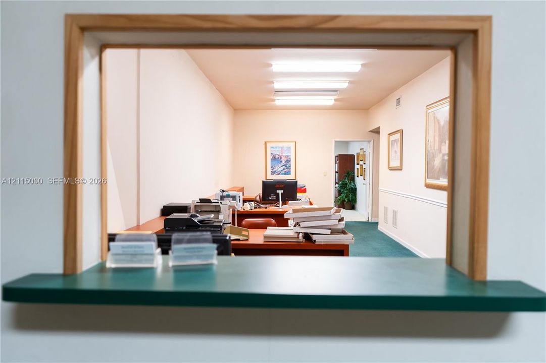 Interior service window featuring a natural wood frame and solid surface counter