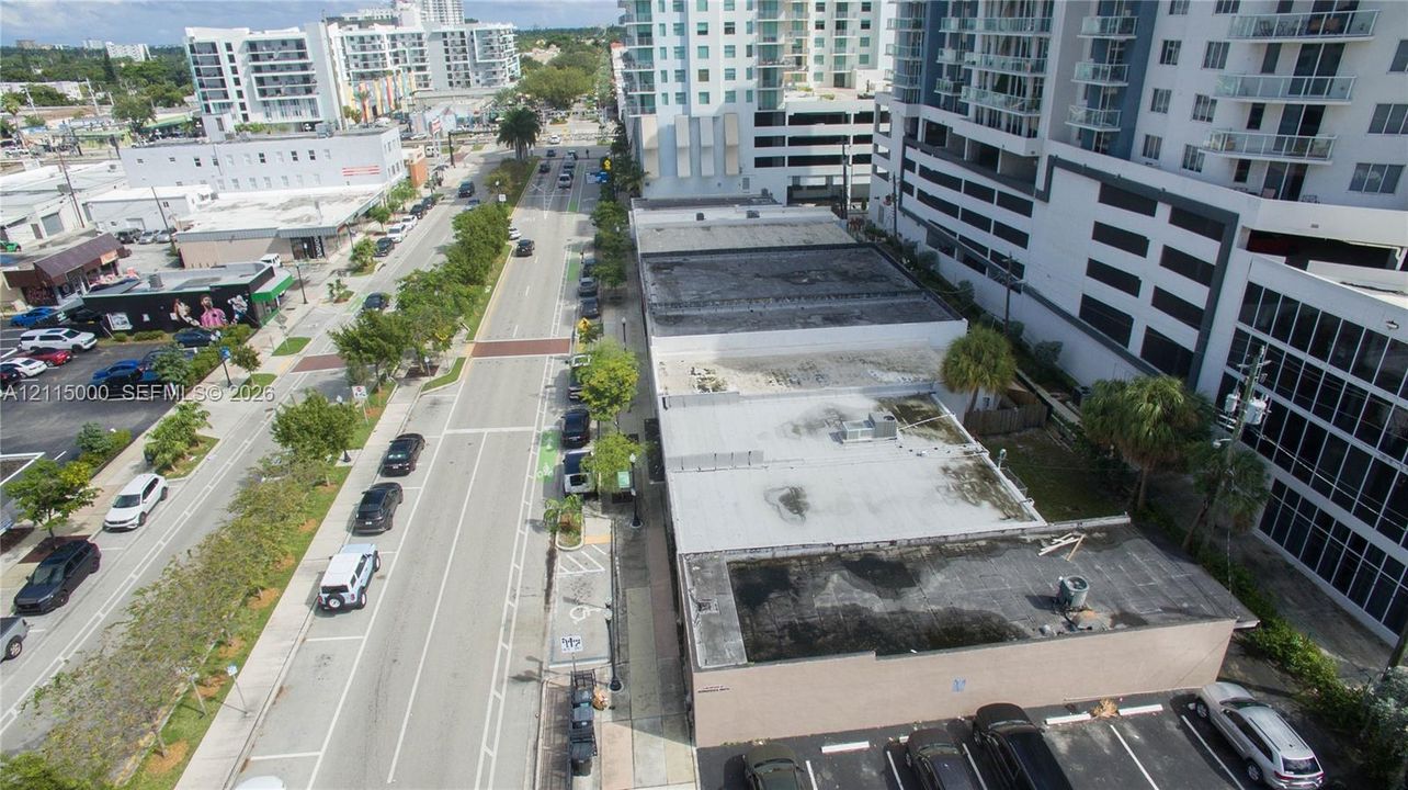 Commercial property featuring flat roof construction and an asphalt-paved surface parking area situated on a public thoroughfare