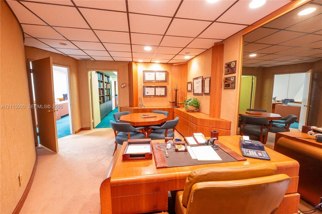Custom built-in wood cabinetry, integrated recessed lighting, drop ceiling grid, and full-wall mirrors