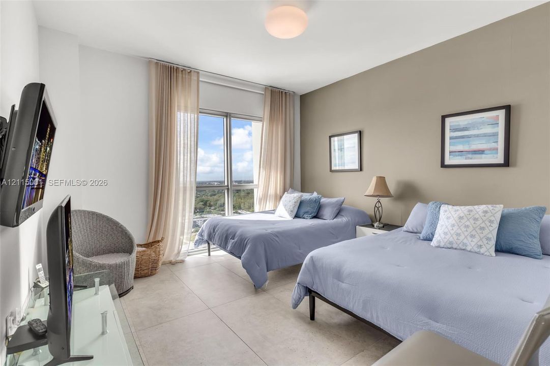 Large-format tile flooring, neutral wall tones, and floor-to-ceiling windows featuring exterior horizon scenery