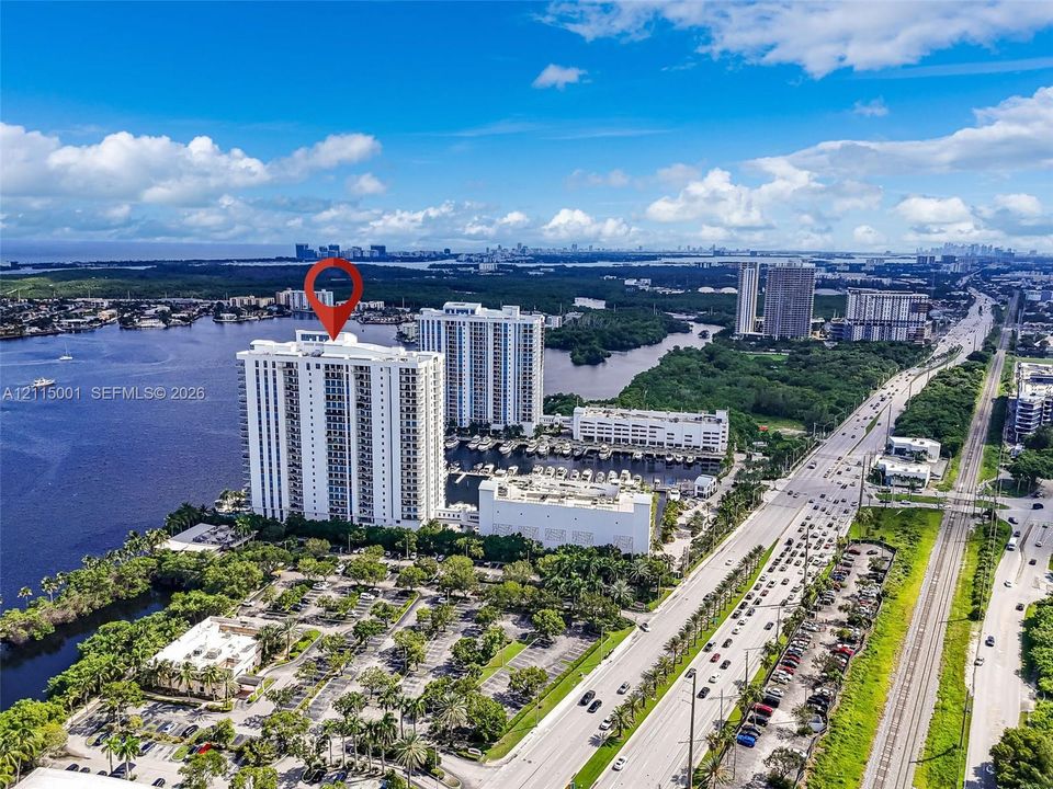 High-rise residential building situated on the waterfront with access to an on-site marina and paved parking areas