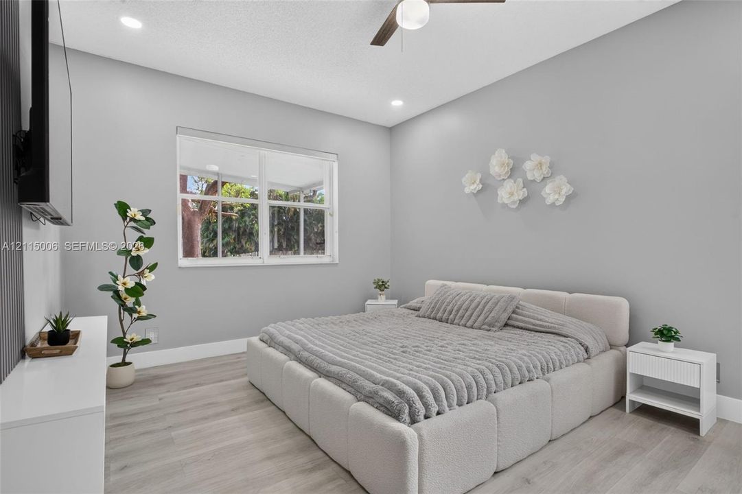 Bedroom featuring light-toned wood-finish flooring, recessed lighting, and a ceiling fan with integrated lighting