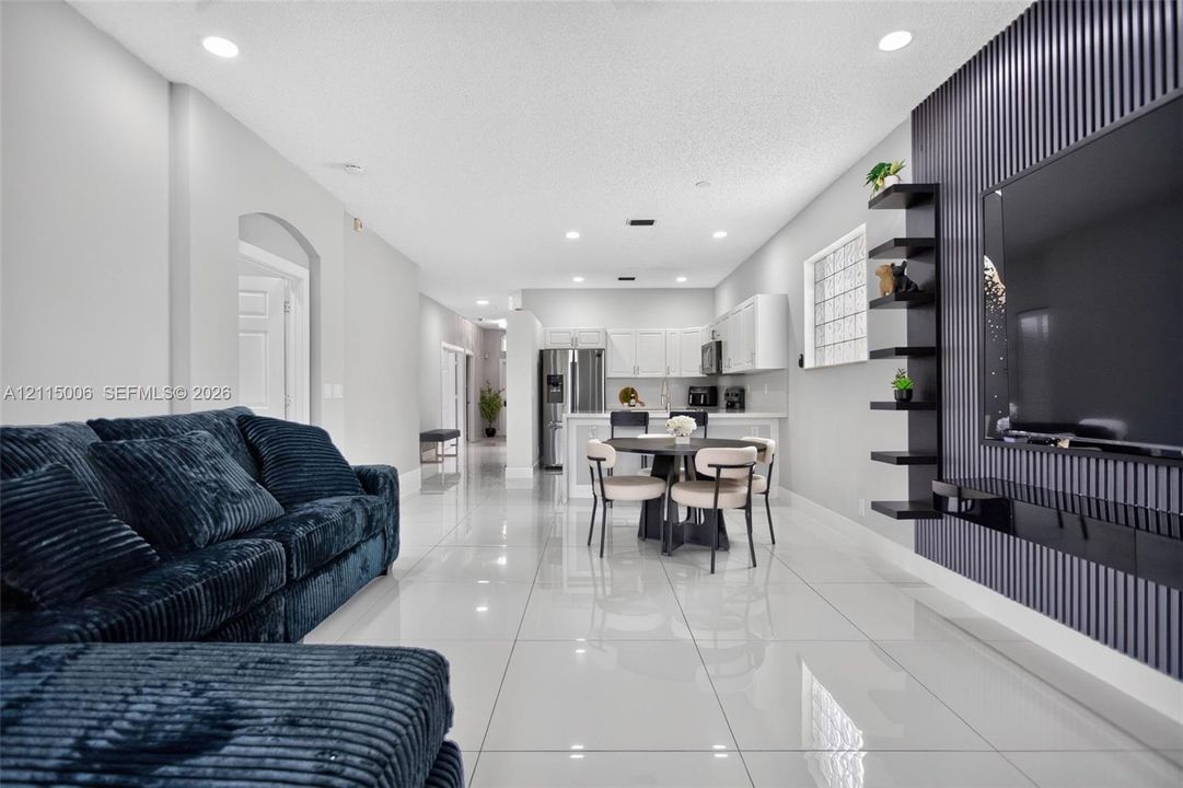 Interior featuring polished tile flooring, recessed lighting, and a vertical slat accent wall with integrated shelving