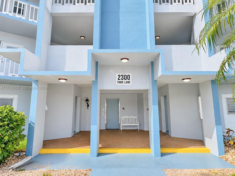 Multi-level exterior featuring concrete structural pillars, covered entryways, inset balconies, and integrated recessed lighting