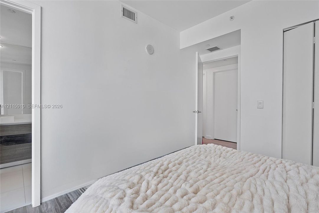 Neutral interior featuring wood-finish flooring, white walls, and a multi-panel closet door