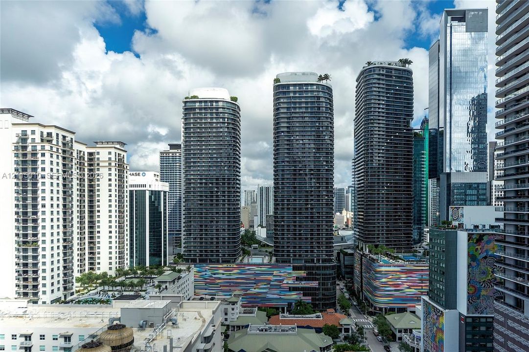 High-rise urban landscape featuring contemporary glass skyscrapers, private balconies, rooftop greenery, and colorful architectural facade accents