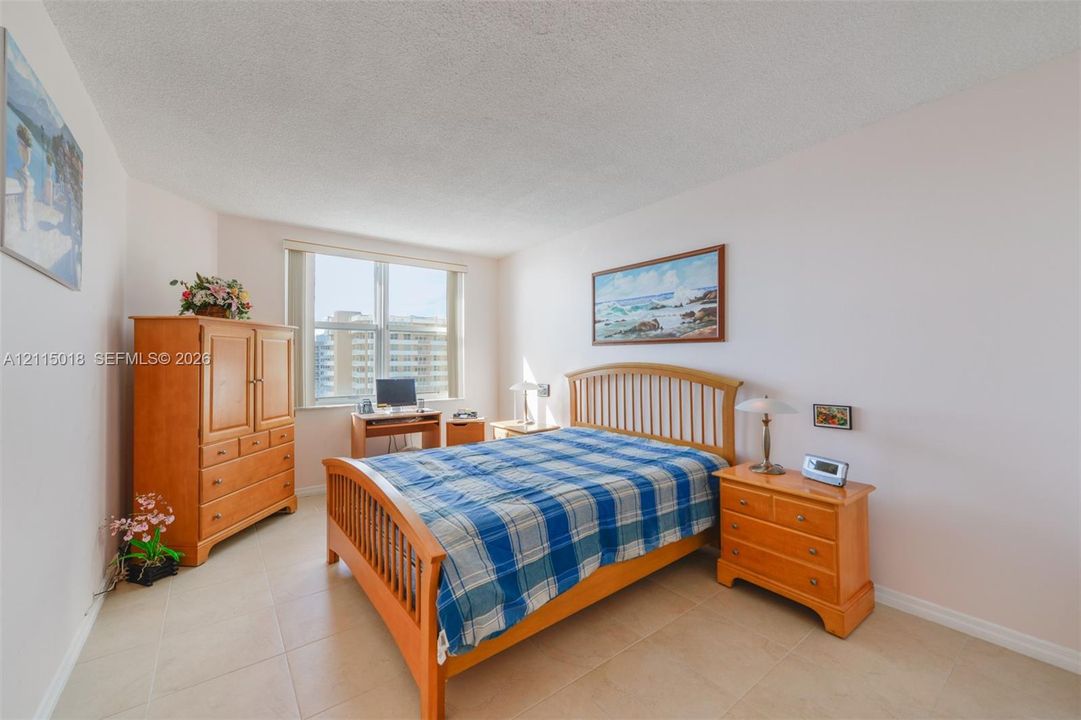 Neutral-toned tile flooring, light-colored walls, and a large window providing natural light