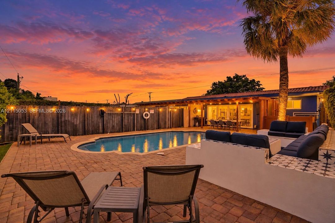 Backyard featuring  heated in-ground swimming pool, built-in masonry seating, and fully enclosed.