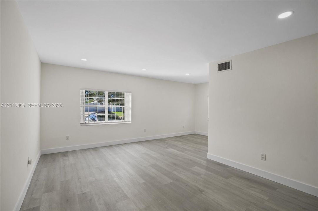 Interior space featuring neutral wall paint, wood-finish flooring, and recessed ceiling lighting