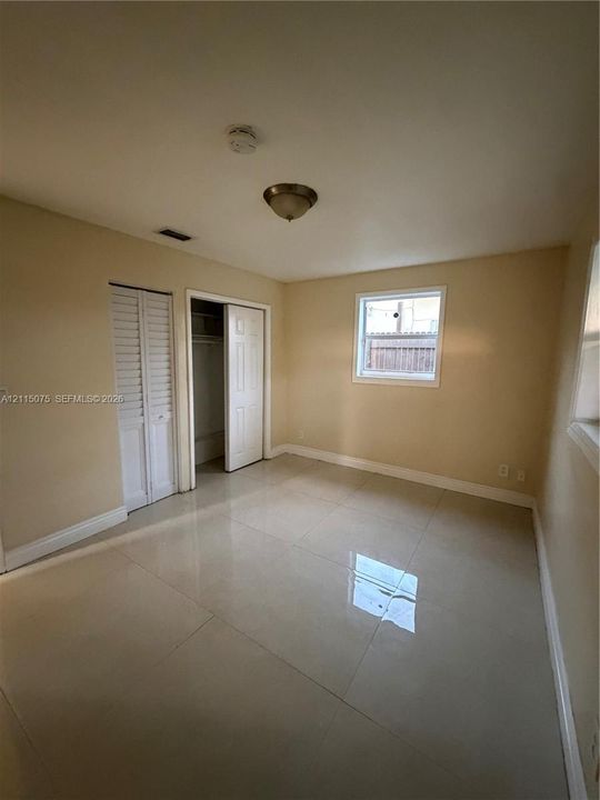 Interior space featuring large-format tile flooring, a dual-door reach-in closet, and a single-window configuration