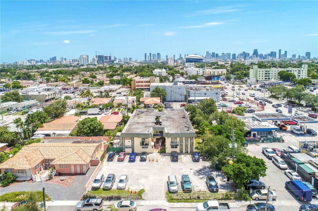 Aerial perspective of a multi-unit property featuring a flat roof structure, masonry exterior, and dedicated surface parking