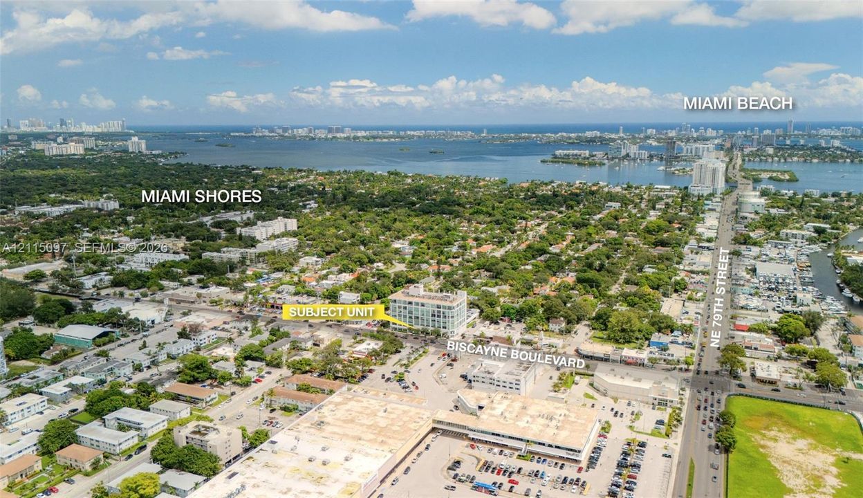 Aerial perspective of a multi-story building positioned near Biscayne Boulevard, featuring proximity to major thoroughfares, Miami Shores, and coastal areas