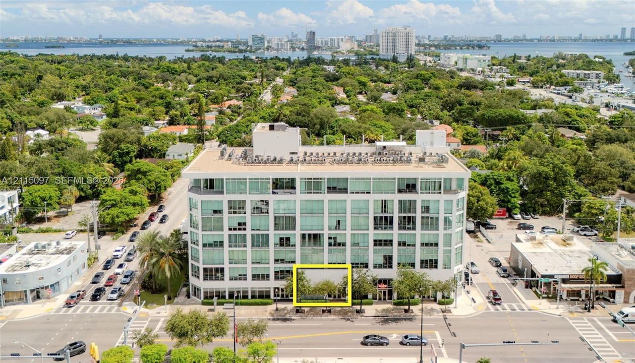Multi-story building with floor-to-ceiling glass windows and exterior landscaping