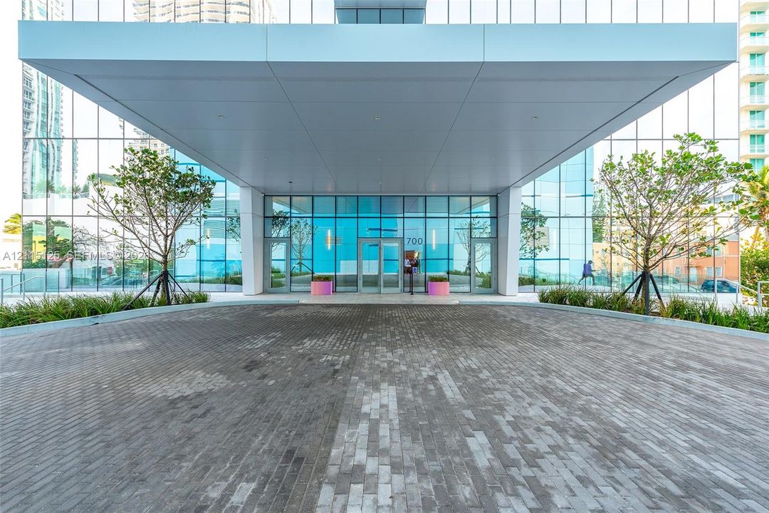 Rooftop tennis court featuring a blue and green multi-surface finish and a white perimeter railing