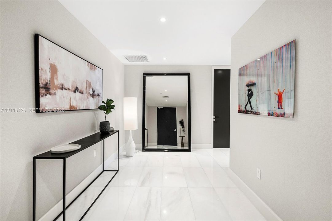 Entryway featuring large-format light tile flooring, solid-core matte black door with integrated hardware, private elevator access, and recessed ceiling lighting