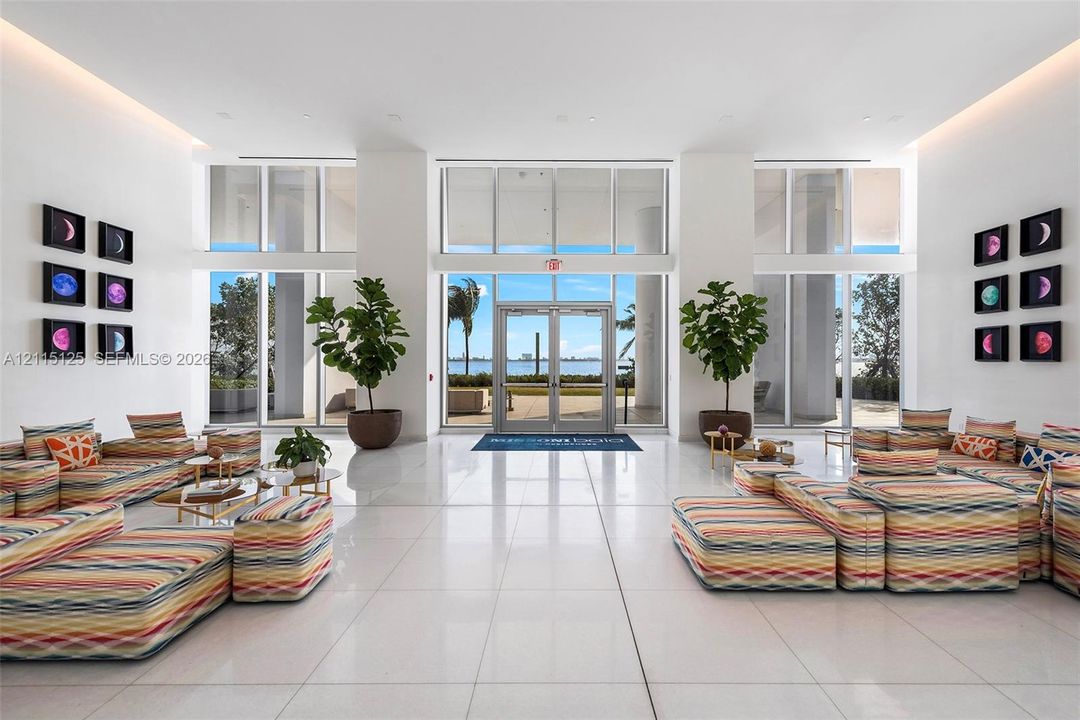 Grand lobby featuring high ceilings, expansive floor-to-ceiling windows, polished stone-finish flooring, and recessed cove lighting